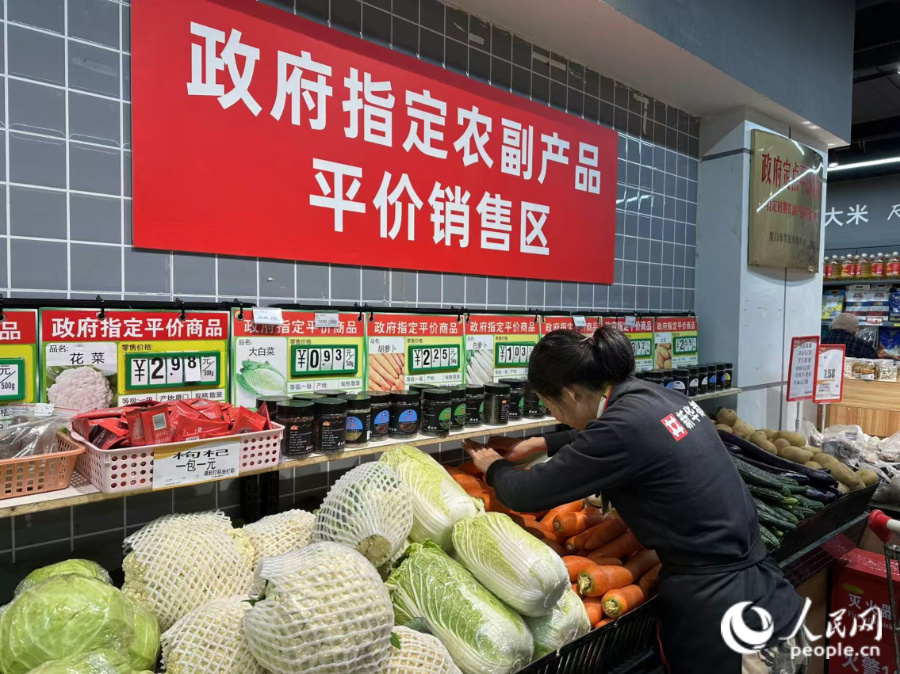 “政府指定農(nóng)副產(chǎn)品平價銷售區(qū)”，工作人員正在補貨。人民網(wǎng)記者 張萌攝