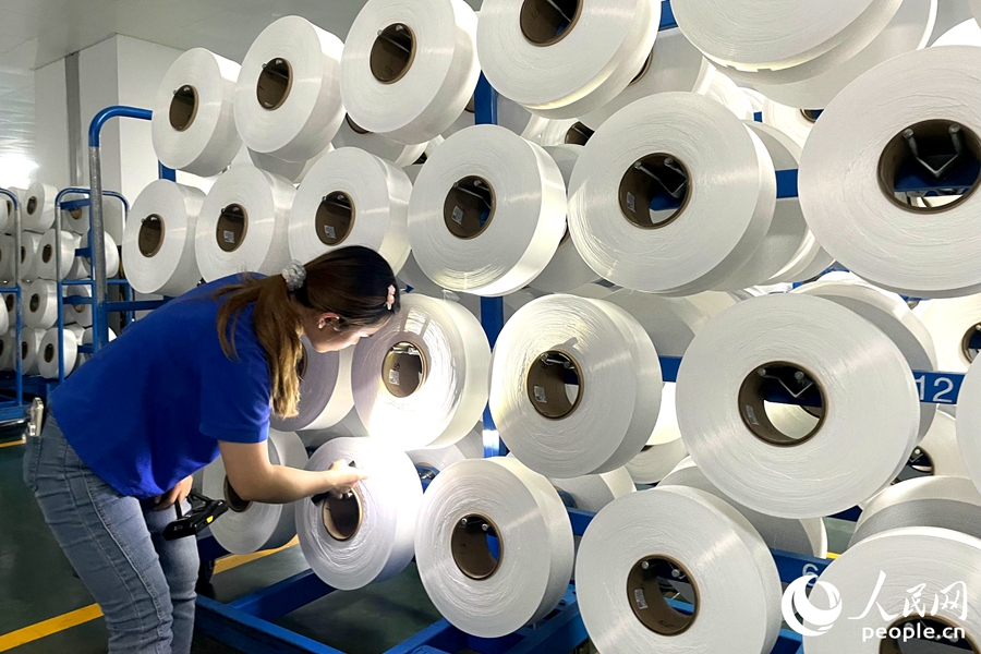 正在對(duì)錦綸成品進(jìn)行品控檢測的工人。人民網(wǎng)記者 林盈攝