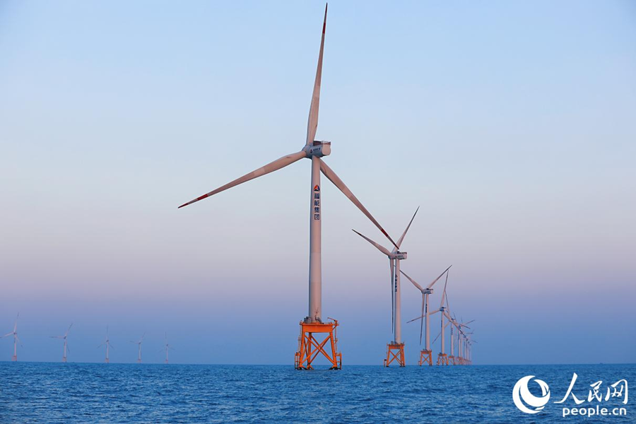 天色漸暗，“海上大風(fēng)車(chē)”被霞光映襯著。人民網(wǎng) 李唯一攝