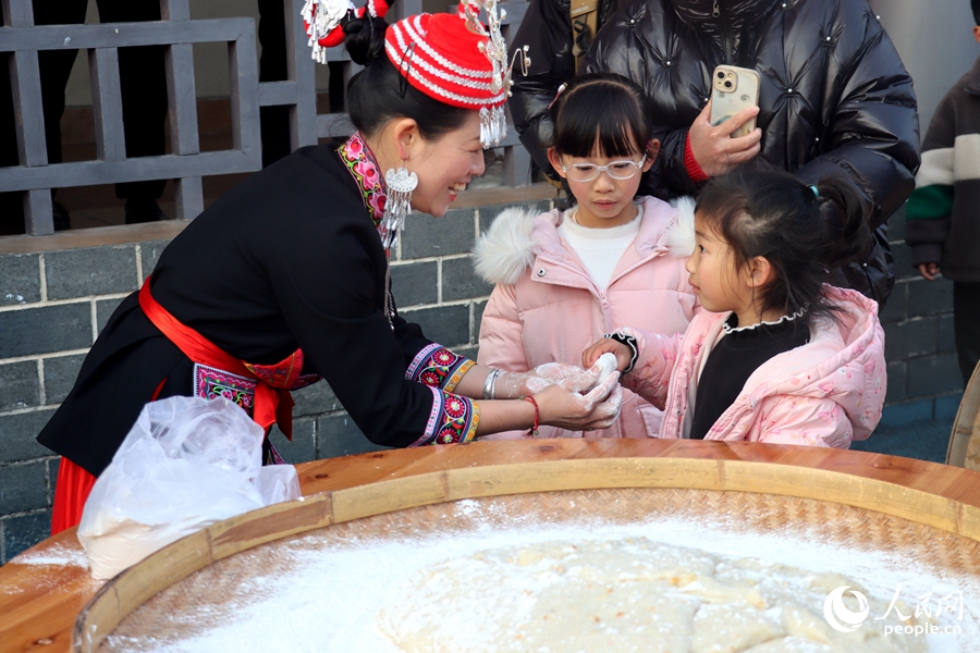 糍粑的香氣引得周圍的孩子們駐足。人民網(wǎng) 謝星宇攝