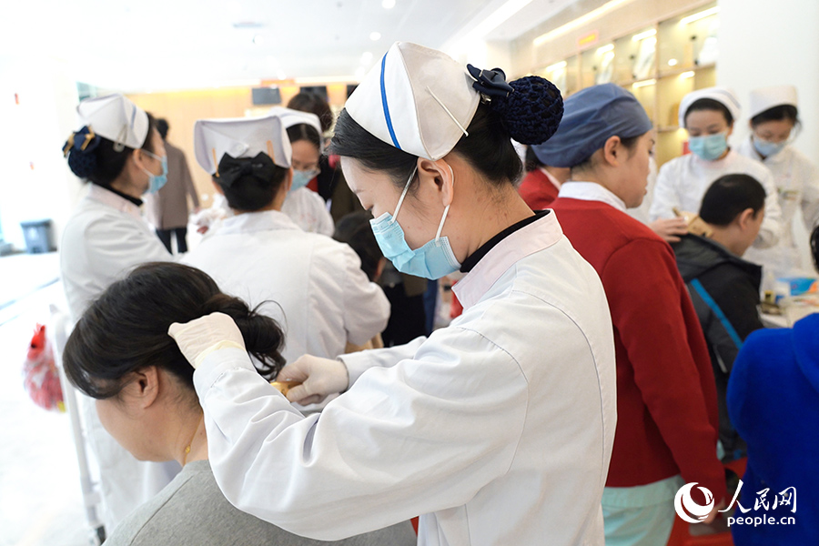 醫(yī)護人員手法嫻熟地為市民提供中醫(yī)適宜技術(shù)體驗。人民網(wǎng) 陳永整攝