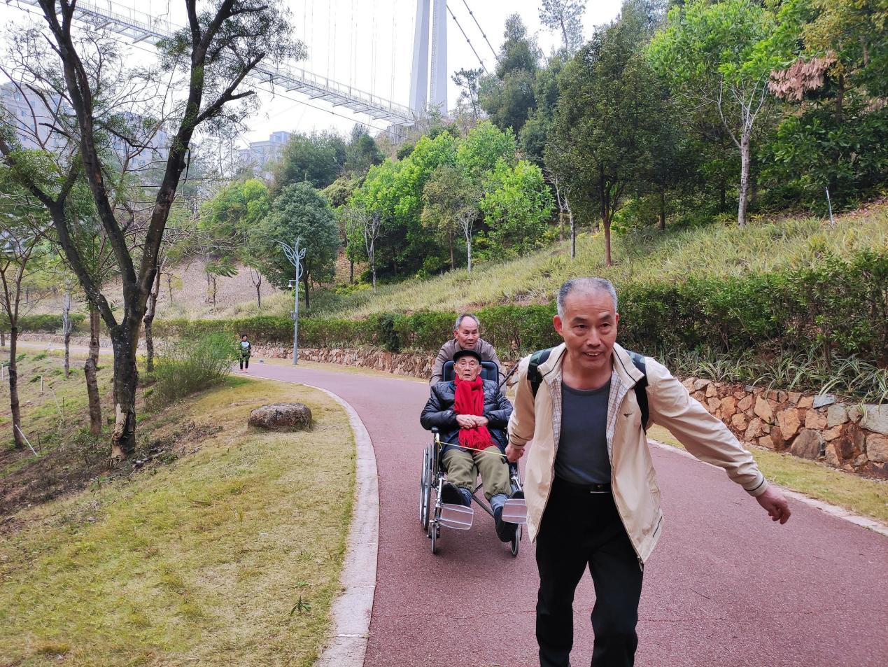 黃光輝、黃永輝兩兄弟合力為父親推拉輪椅。受訪者供圖