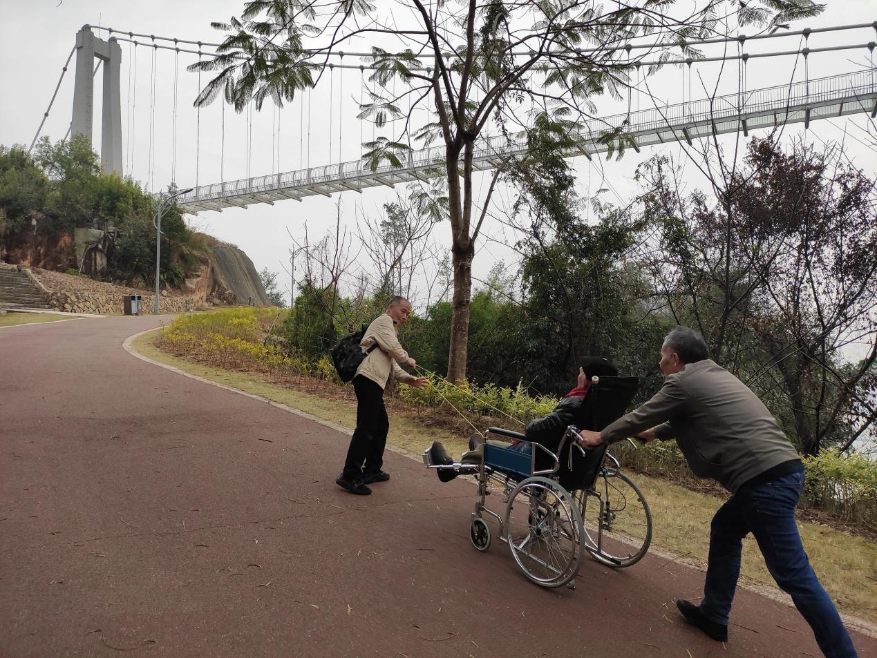 黃光輝、黃永輝兩兄弟合力為父親推拉輪椅。受訪者供圖