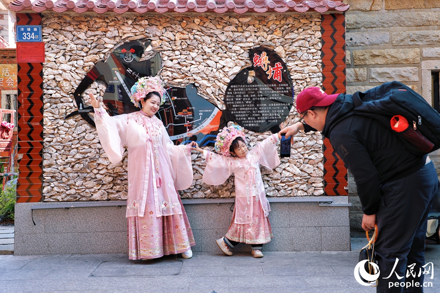 游客在蟳埔村頭戴簪花拍照留念。人民網(wǎng) 李唯一攝