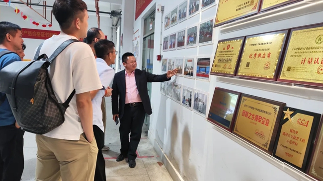 尋親代表團在村中走訪參觀，了解該村發(fā)展的團餐產(chǎn)業(yè)