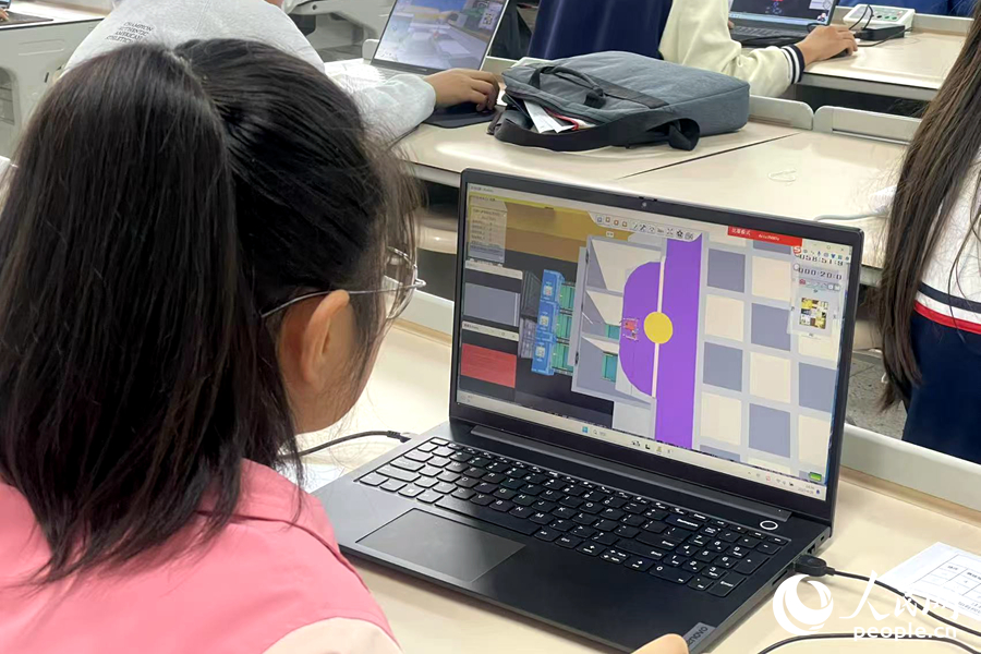 選手在調(diào)試“未來工廠”虛擬機(jī)器人。人民網(wǎng)記者 林盈攝