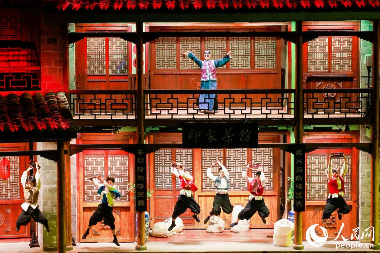 王龍濤（上）飾演茶掌柜帶領(lǐng)茶廠的伙計(jì)，為五湖四海的茶商計(jì)算“武夷四大名樅”的價(jià)格。人民網(wǎng) 李唯一攝