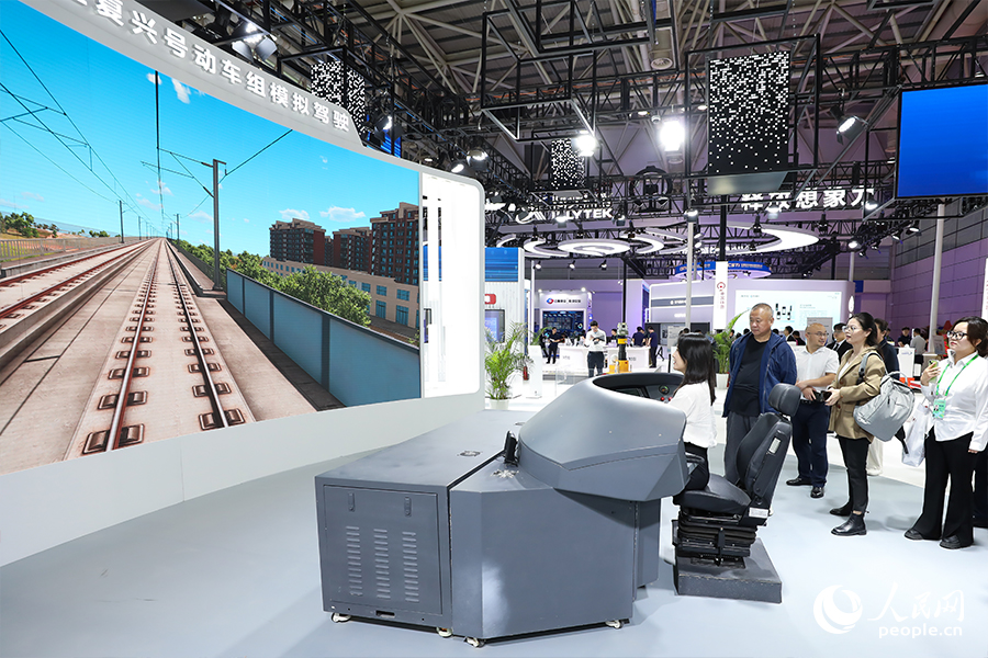 市民在現(xiàn)場體驗(yàn)區(qū)當(dāng)復(fù)興號(hào)司機(jī)，體驗(yàn)時(shí)速350公里的復(fù)興號(hào)。人民網(wǎng) 陳永整攝