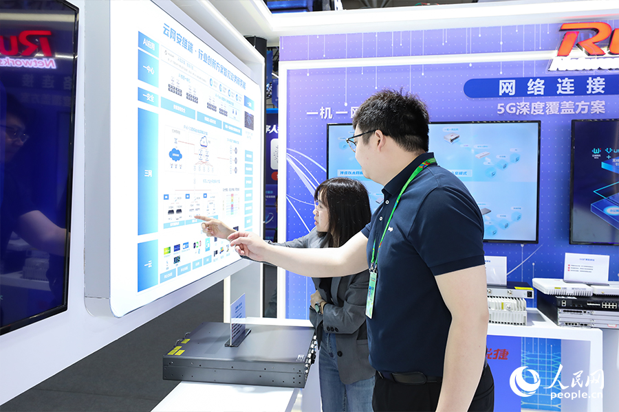 在福建省電子信息集團(tuán)展區(qū)，工作人員為市民介紹創(chuàng)新方案。人民網(wǎng) 陳永整攝