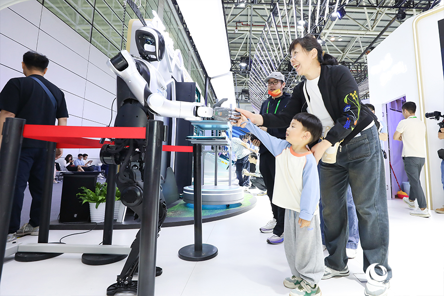 展區(qū)現(xiàn)場，小朋友和機器人互動握手。人民網(wǎng) 陳永整攝