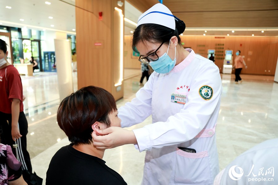 市民體驗(yàn)耳穴壓豆中醫(yī)適宜技術(shù)。人民網(wǎng) 陳永整攝