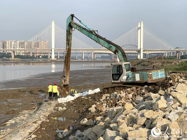 工人搶在漲潮前做好護堤作業(yè)。人民網(wǎng)記者 陳藍燕攝