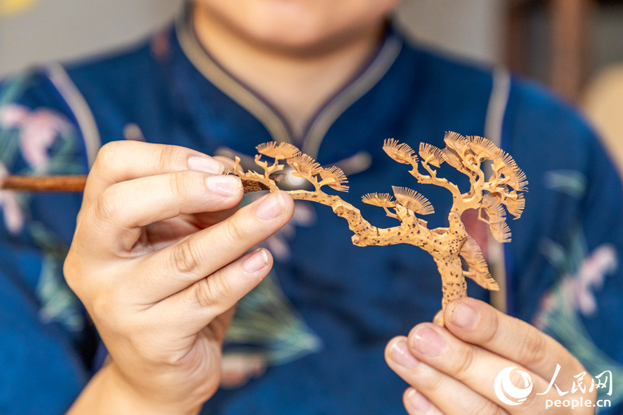 制作軟木畫要在薄如蟬翼的樹皮上純手工刻畫人物、山水、花鳥、亭臺、樓閣，最細(xì)微的部件薄至0.1微米。人民網(wǎng) 楊灝昱攝