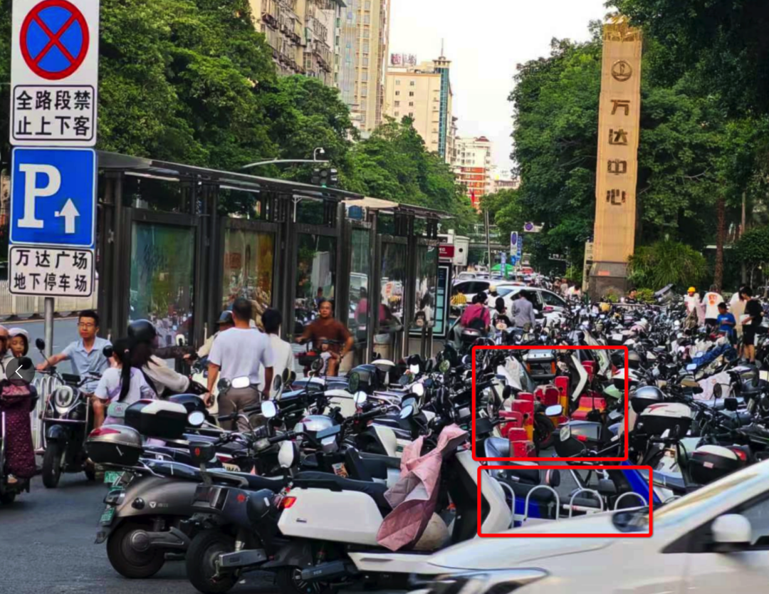浦西公交站背后路段設(shè)置了非機(jī)動車停車區(qū)域，但仍有大量電動車直接停放在白色護(hù)欄和紅色隔離墩（紅框位置）外的非機(jī)動車道上。李先生攝于7月2日