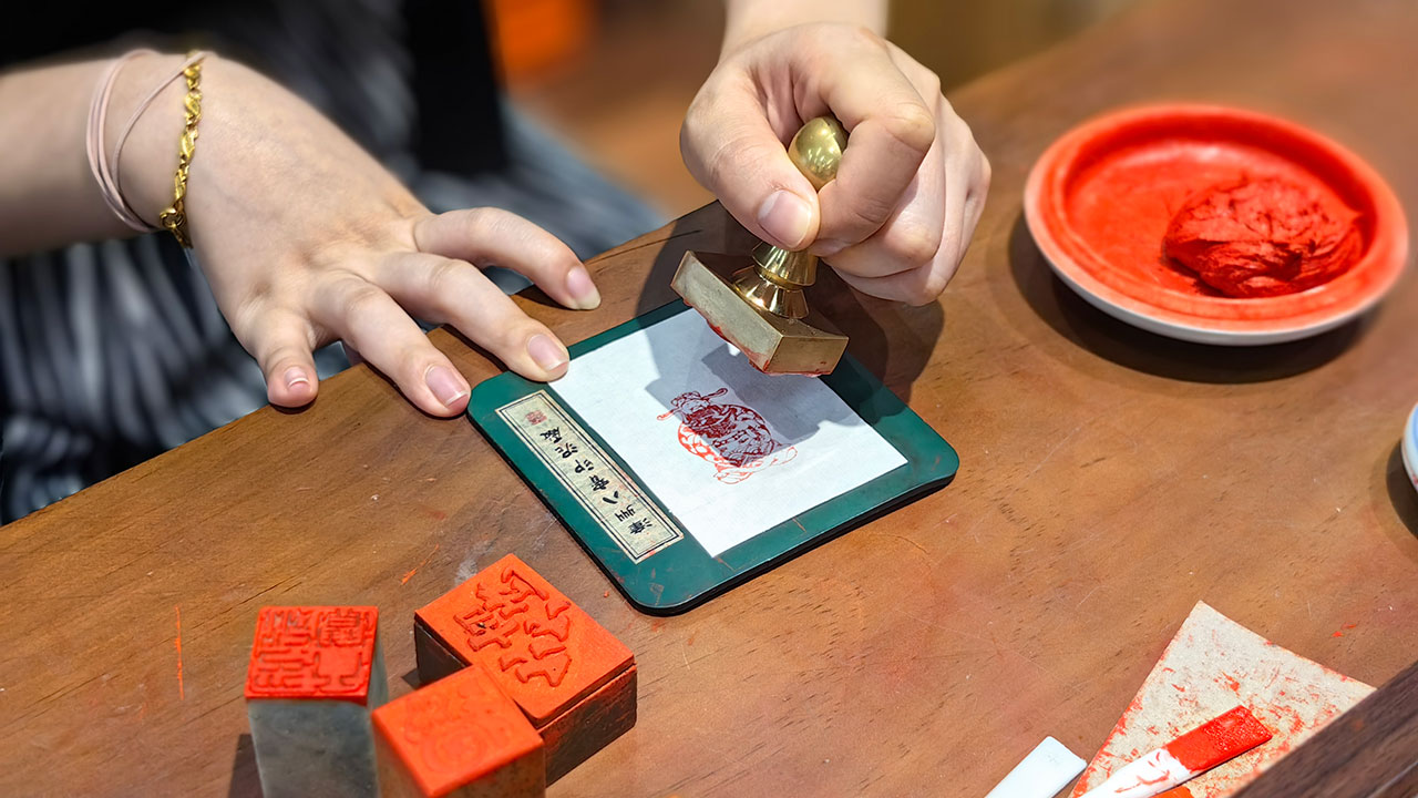 游客在漳州古城體驗(yàn)八寶印泥拓印