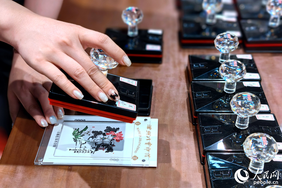 游客現(xiàn)場體驗用多彩印泥套印文創(chuàng)紀(jì)念品。人民網(wǎng) 葉青卿攝