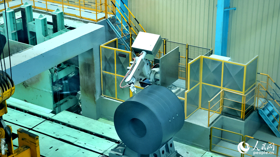 工業(yè)機器人替代人工對新出爐的鋼卷進行噴涂作業(yè)。人民網(wǎng) 李昌乾攝