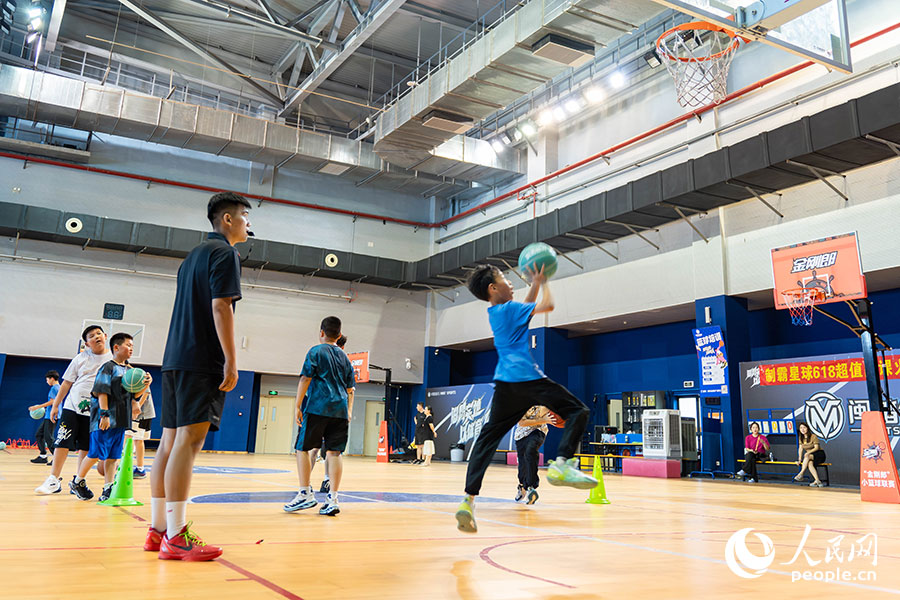 7月13日，位于福建晉江的安踏全民健身運(yùn)動(dòng)中心籃球館內(nèi)，學(xué)生在暑期籃球訓(xùn)練營中進(jìn)行籃球基本功訓(xùn)練。實(shí)習(xí)生 林靜茹攝