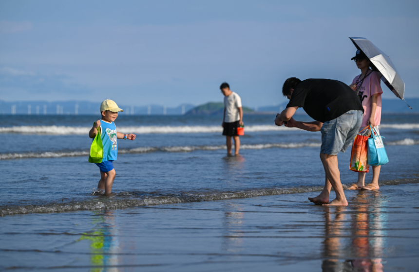 小朋友“全副武裝”在海邊玩水。林雙偉攝