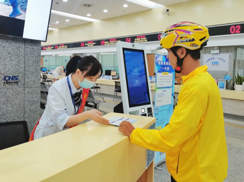 醫(yī)保工作人員向外賣小哥解讀靈活就業(yè)人員參保政策。