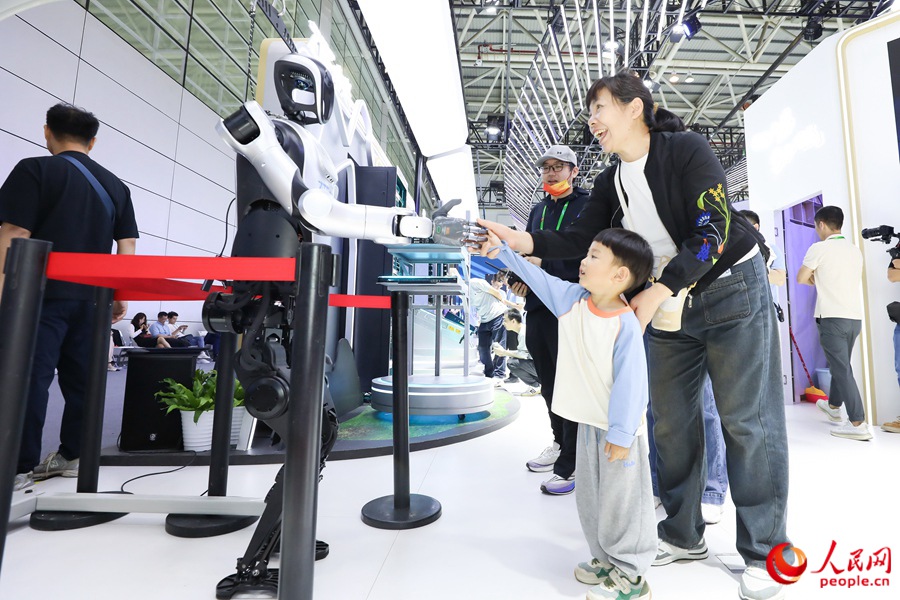 第八屆數(shù)字中國建設峰會上，小朋友和機器人互動握手。人民網(wǎng) 陳永整攝