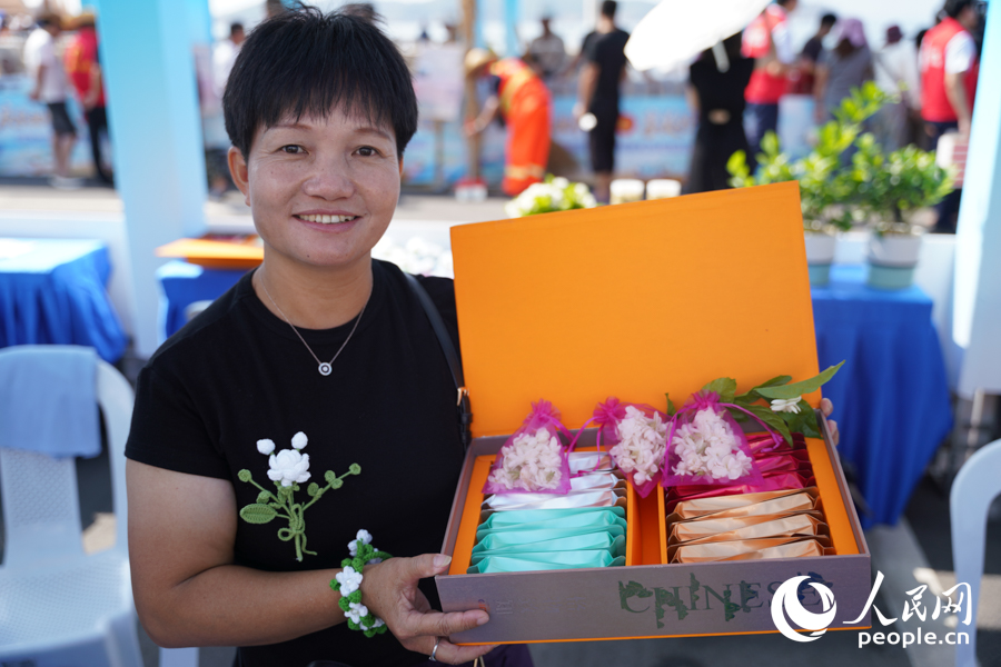 當?shù)睾献魃缯逛N自產(chǎn)茉莉花茶和針織茉莉花飾品。實習生 鄭舒塵攝
