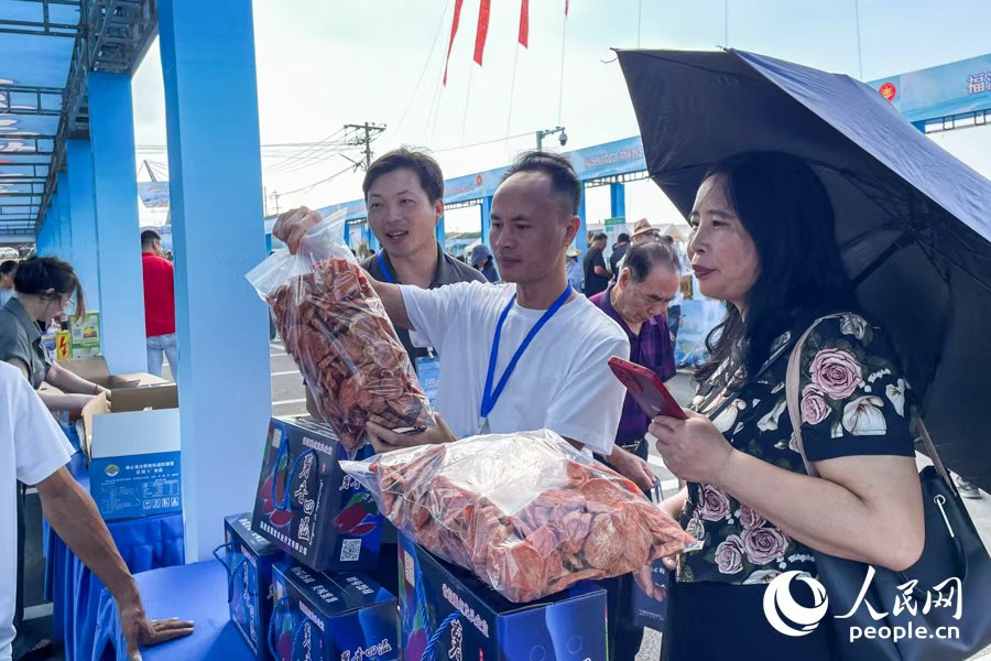 游客挑選當?shù)靥厣r(nóng)產(chǎn)品。人民網(wǎng)記者 林盈攝