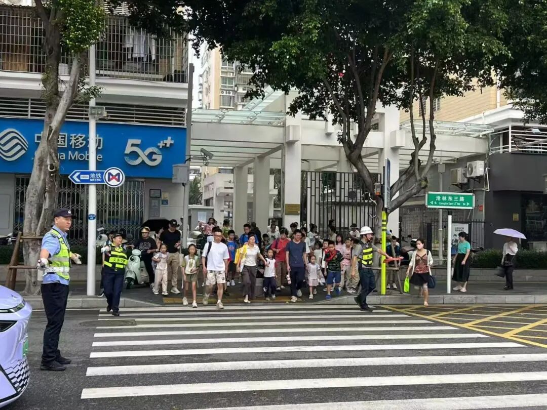 民警輔警熟練地疏導(dǎo)車流，保障學(xué)生們的安全