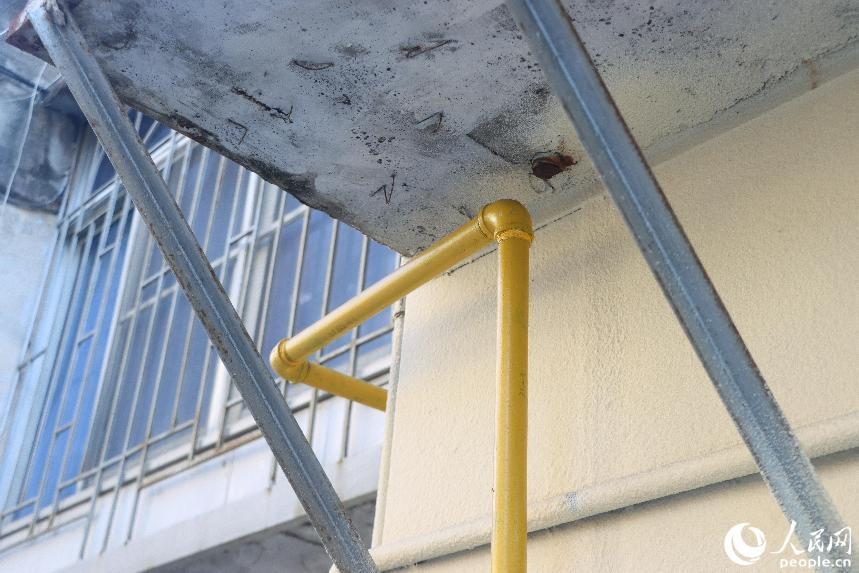黃色的新管道與曾經從戶內穿過的舊管道痕跡。人民網 林銘賢攝