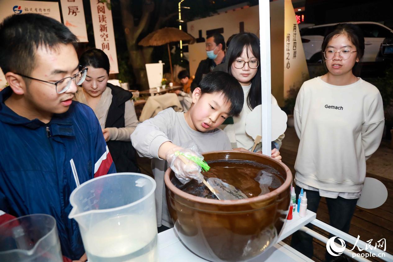 讀者們現(xiàn)場體驗漆扇制作，留念這段茶香漫溢的時光。人民網(wǎng)記者 陳永整攝