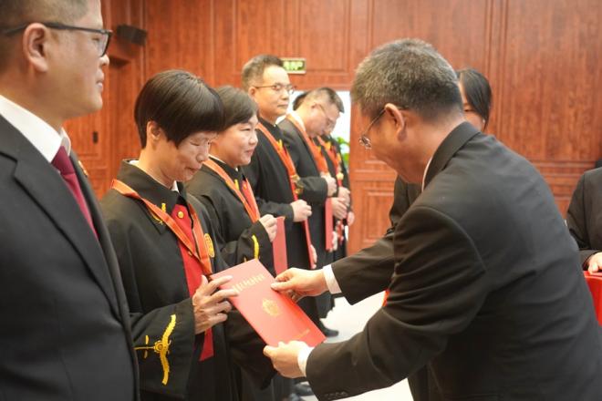 為廈門法院干警頒發(fā)“榮譽天平紀念章”。廈門中院供圖