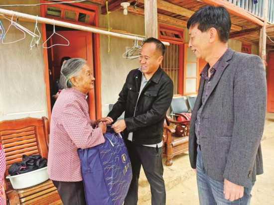周桂平（中）為高齡老人送去冬被。
